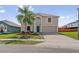 Charming two-story home featuring a well-maintained lawn, a large palm tree, and a two-car garage at 328 Fairfield Dr, Sanford, FL 32771