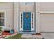 Charming blue front door with sidelights and decorative wreath and a two-car garage on the side at 328 Fairfield Dr, Sanford, FL 32771