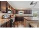 Modern kitchen with updated appliances, brown cabinets, and granite countertops at 328 Fairfield Dr, Sanford, FL 32771