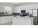 Modern kitchen with white cabinets, stainless steel appliances, and a stylish gray tile backsplash at 353 Belmond Dr, Debary, FL 32713