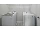 Well-equipped laundry room with modern, white, front-loading washer and dryer at 353 Belmond Dr, Debary, FL 32713
