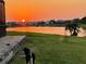 Picturesque sunset view over the lake from a backyard with a dog, perfect for evening relaxation at 3774 Eagle Isle Cir, Kissimmee, FL 34746