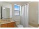 Bathroom with sink, large mirror, and tub/shower featuring a curtain, offering a practical and clean space at 3774 Eagle Isle Cir, Kissimmee, FL 34746