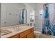 Well-maintained bathroom featuring a vanity with sink, toilet, and shower-tub combination with decorative curtain at 3774 Eagle Isle Cir, Kissimmee, FL 34746