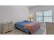 Cozy bedroom features a comfortable bed, neutral walls, tiled flooring, and natural light from the window at 3774 Eagle Isle Cir, Kissimmee, FL 34746