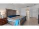 Spacious bedroom featuring a sizable bed, tile floors and a nightstand with a lamp at 3774 Eagle Isle Cir, Kissimmee, FL 34746