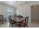 Elegant dining room with classic chandelier and bright natural light from the window at 3774 Eagle Isle Cir, Kissimmee, FL 34746