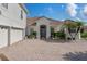 Beautiful white stucco home with a tile roof, a two-car garage and a brick-paved driveway at 3774 Eagle Isle Cir, Kissimmee, FL 34746