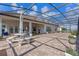 Spacious screened-in lanai featuring a brick patio, elegant patio furniture, and serene outdoor living space at 3774 Eagle Isle Cir, Kissimmee, FL 34746