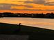 Beautiful sunset water view, showcasing a serene lake with wildlife in silhouette against an orange sky at 3774 Eagle Isle Cir, Kissimmee, FL 34746