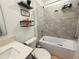 Well-lit bathroom with a tub-shower combination and vanity shelves at 4295 Twisted Twig Bnd, Kissimmee, FL 34746