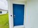 The vibrant blue front door makes a welcoming statement with modern smart lock at 4295 Twisted Twig Bnd, Kissimmee, FL 34746
