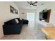 Comfortable living room featuring a large sectional sofa, a ceiling fan, and a wall-mounted TV at 4295 Twisted Twig Bnd, Kissimmee, FL 34746