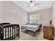 Bright bedroom featuring a ceiling fan, window, and neutral walls with a crib for a baby at 4356 S Kirkman Rd # 514, Orlando, FL 32811