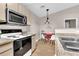 Cozy kitchen with stainless steel microwave, wooden cabinetry, and adjacent dining space at 4356 S Kirkman Rd # 514, Orlando, FL 32811