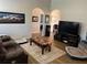 Comfortable living room with hardwood floors, a plush sofa, and an entertainment center with a large TV at 4805 Sw 171St Ct, Dunnellon, FL 34432