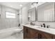 Modern bathroom with double vanity, wood cabinets, tub and tiled walls at 500 Vereen Dr, Maitland, FL 32751