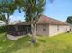 Home exterior featuring screened-in lanai, lawn, and mature trees at 813 Lancer Cir, Ocoee, FL 34761