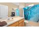 Bright bathroom with a large mirror, oak vanity, and blue marble shower curtain at 813 Lancer Cir, Ocoee, FL 34761