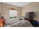 Comfortable bedroom features neutral tones, large window, TV and ceiling fan at 813 Lancer Cir, Ocoee, FL 34761