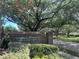 Community entrance to Admiral Pointe, a private lakefront community, framed by lush greenery and mature trees at 813 Lancer Cir, Ocoee, FL 34761