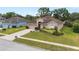 Landscaped front yard with green grass, colorful flowers and a long driveway at 813 Lancer Cir, Ocoee, FL 34761