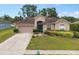Inviting home with manicured lawn, flowerbeds, and a striking blue front door at 813 Lancer Cir, Ocoee, FL 34761