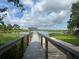 Scenic lake view from the dock, showcasing tranquil waters, lush vegetation, and clear skies, an ideal spot for relaxation at 813 Lancer Cir, Ocoee, FL 34761
