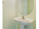 Half bath featuring a pedestal sink and a round mirror at 9492 Flowering Cottonwood Rd # 82, Orlando, FL 32832