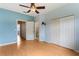 Spacious bedroom with light blue walls, ceiling fan, and closet space at 9492 Flowering Cottonwood Rd # 82, Orlando, FL 32832