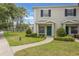Inviting townhome featuring a well-manicured lawn and charming curb appeal with a green door at 9492 Flowering Cottonwood Rd # 82, Orlando, FL 32832