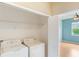 Bright laundry room boasts shelving and white appliances, conveniently located near a bedroom for ease of use at 9492 Flowering Cottonwood Rd # 82, Orlando, FL 32832