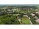 Aerial view of a plot of land in a developed community, featuring mature trees and a nearby golf course at 9517 San Fernando Ct, Howey In The Hills, FL 34737