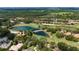 Scenic aerial view of a golf course community featuring a charming stone bridge and well-manicured grounds at 9517 San Fernando Ct, Howey In The Hills, FL 34737