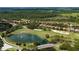 Stunning aerial view of a golf course community with a picturesque lake and charming stone bridge at 9517 San Fernando Ct, Howey In The Hills, FL 34737