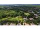 Aerial view of a plot of land in a developed community near a golf course, trees, and other residential homes at 9517 San Fernando Ct, Howey In The Hills, FL 34737