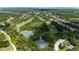 Beautiful aerial view of community tennis courts surrounded by lush landscapes and a golf course at 9517 San Fernando Ct, Howey In The Hills, FL 34737