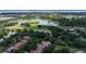 Stunning aerial view of golf course community, featuring lush greenery, a serene lake, and beautiful homes at 9517 San Fernando Ct, Howey In The Hills, FL 34737
