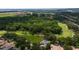 A high aerial view of a homesite surrounded by lush greenery and mature trees in a golf community at 9517 San Fernando Ct, Howey In The Hills, FL 34737