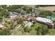 Aerial view showcasing the clubhouse, pool, tennis courts, and meticulously landscaped grounds at 9517 San Fernando Ct, Howey In The Hills, FL 34737