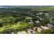 Aerial view of a green parcel of land, golf course, and residential community with ponds and trees at 9517 San Fernando Ct, Howey In The Hills, FL 34737