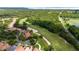 Expansive aerial view of a lush golf course community with beautiful homes and winding roads at 9517 San Fernando Ct, Howey In The Hills, FL 34737