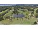 Scenic aerial view of a meticulously maintained golf course with a picturesque lake at 9517 San Fernando Ct, Howey In The Hills, FL 34737