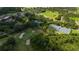 Aerial shot showcases the community's well-maintained tennis courts surrounded by mature trees and lush landscaping at 9517 San Fernando Ct, Howey In The Hills, FL 34737
