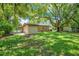 Expansive backyard featuring a well-maintained lawn, storage shed, and mature shade trees at 102 Mayrose Dr, Sanford, FL 32771