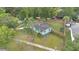 Aerial view of a well-maintained property featuring a green lawn, privacy fence, and a charming, light-colored home at 1210 S Palmetto Ave, Sanford, FL 32771
