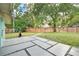 Spacious backyard with a concrete patio, lush lawn, mature trees, and a privacy fence at 1210 S Palmetto Ave, Sanford, FL 32771
