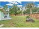 Picture of the home's wide backyard with a green lawn, wooden fence, garden beds and a concrete patio at 1210 S Palmetto Ave, Sanford, FL 32771