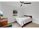 Bright bedroom features terrazzo floors, white walls, ceiling fan, and a window view of the yard at 1210 S Palmetto Ave, Sanford, FL 32771