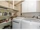 Functional laundry room with washer, dryer, storage shelves and white cabinets at 1210 S Palmetto Ave, Sanford, FL 32771